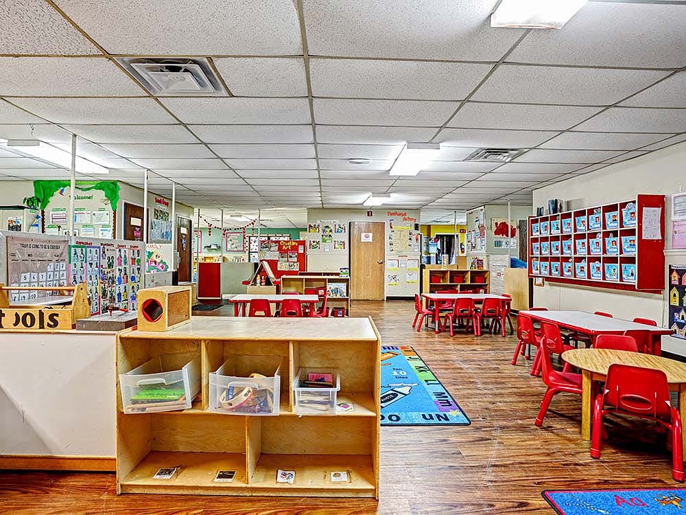 Colorful preschool classroom with child-sized tables and chairs