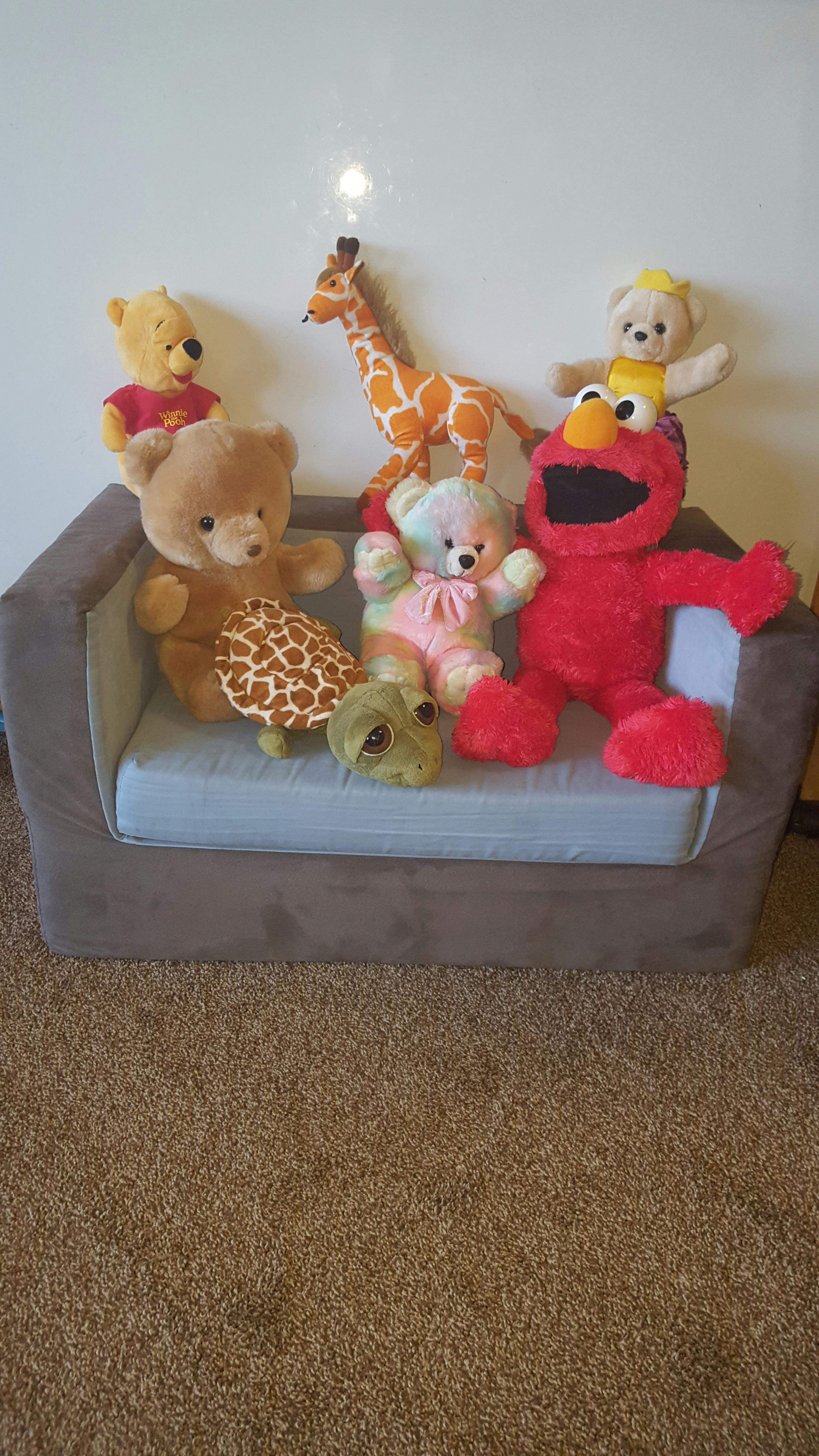 Assortment of stuffed animals on a small couch