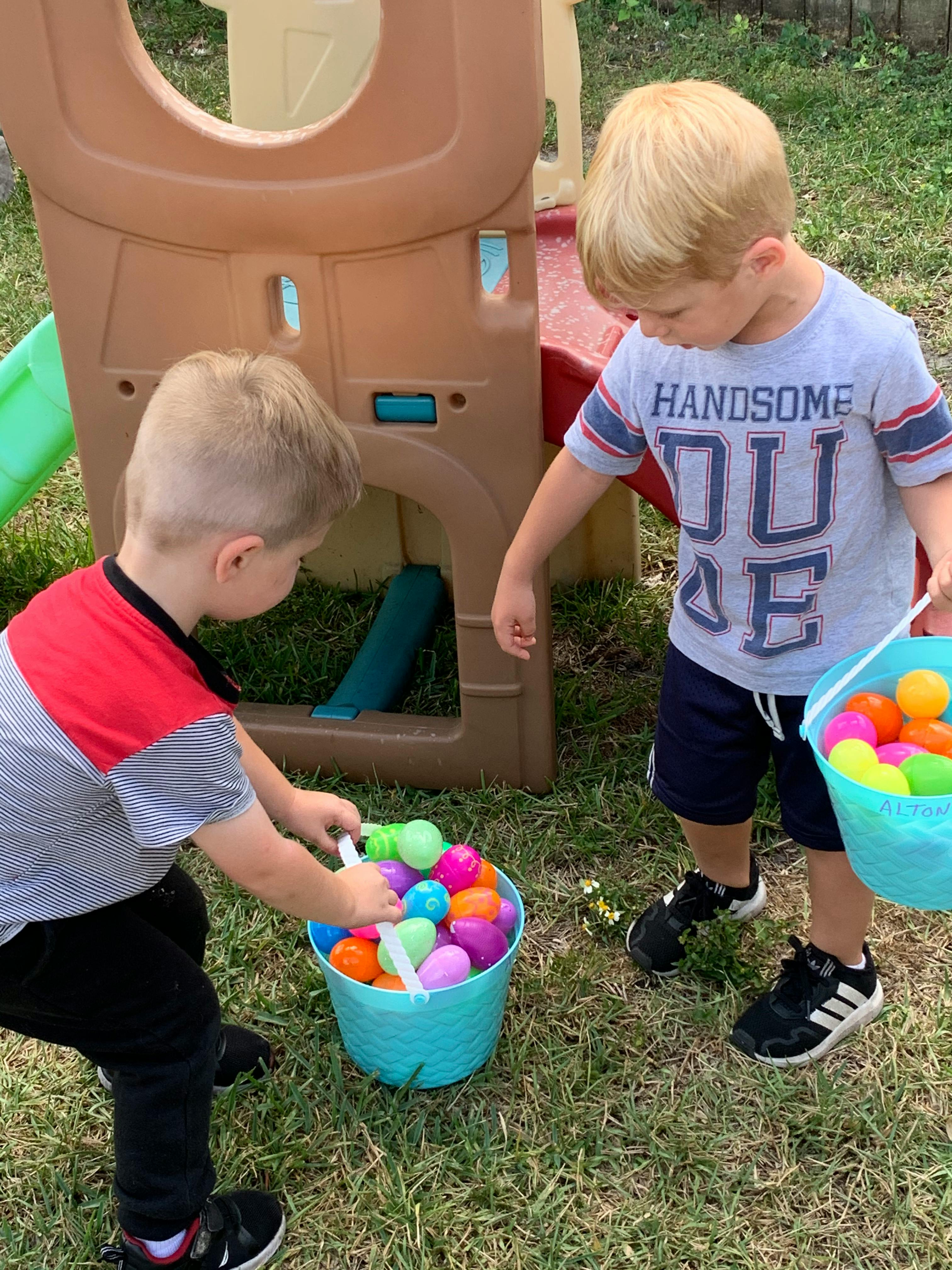 Two children with buckets of colorful plastic eggs