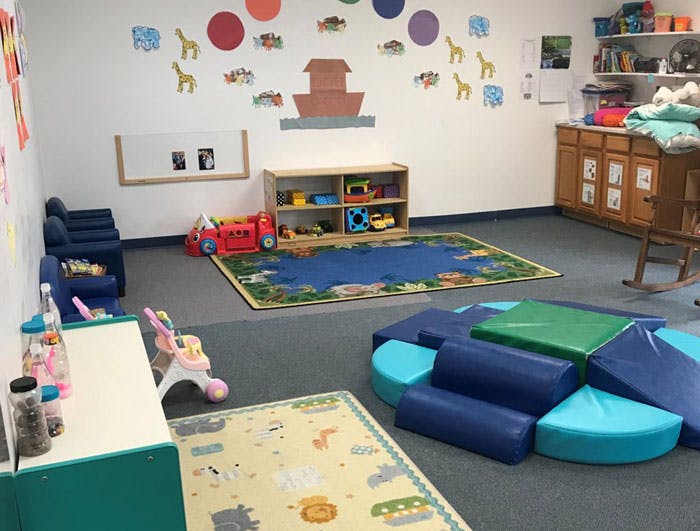 Playroom with soft play equipment, rugs, and toys