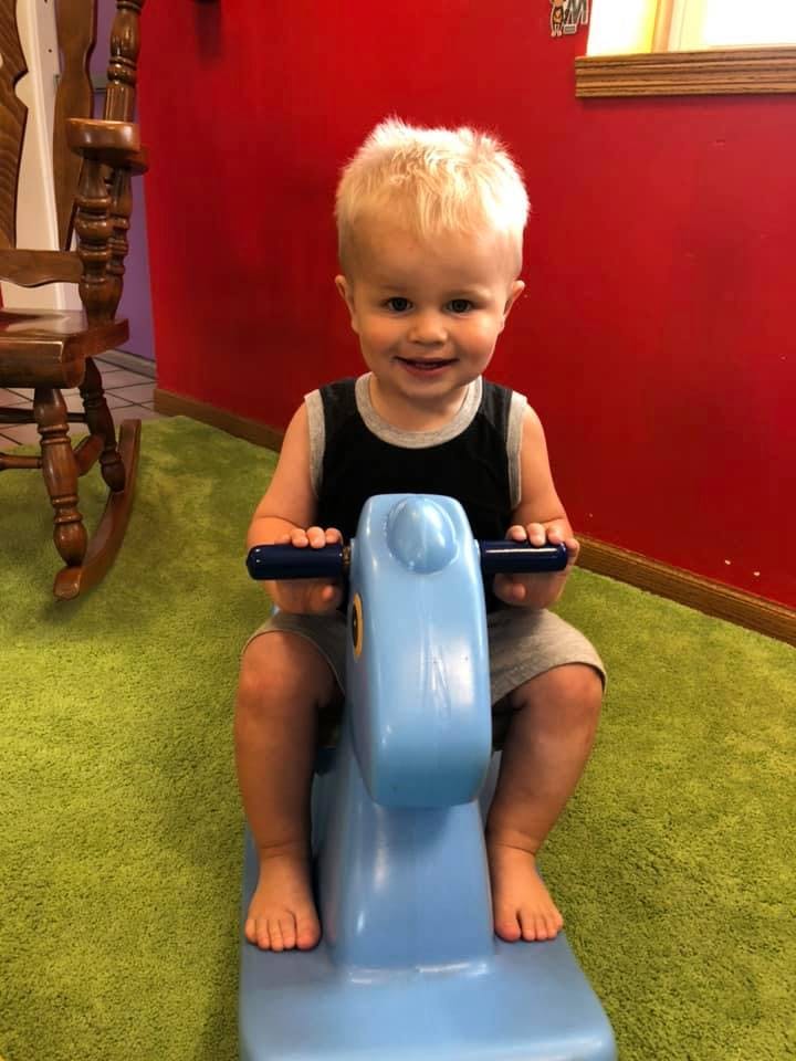 Child on a blue rocking horse