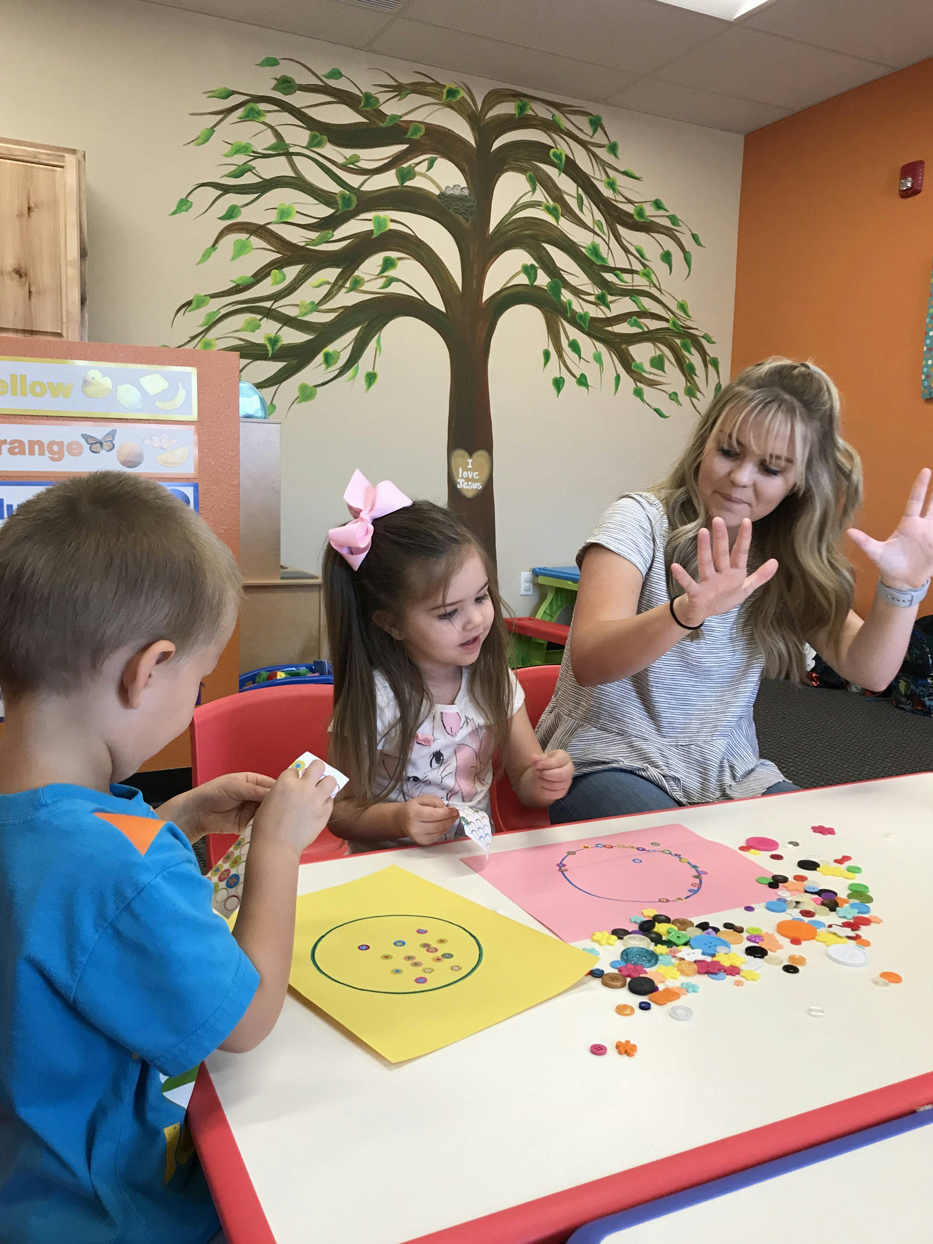 Adult and two children doing crafts at a table