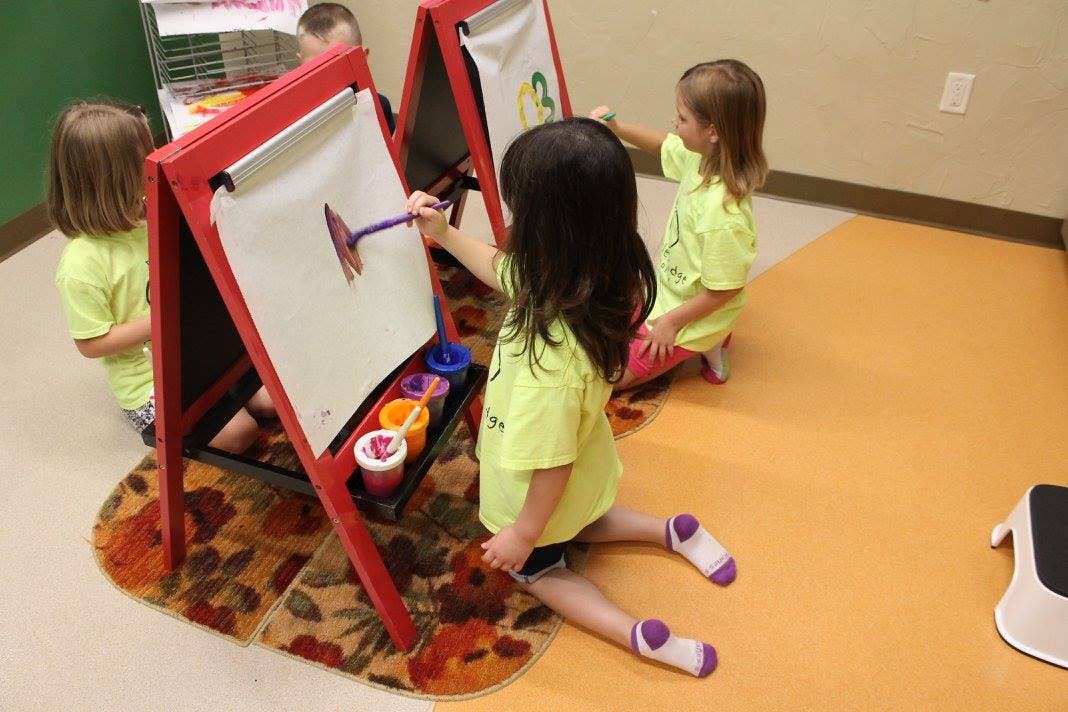 Children painting at easels in a classroom