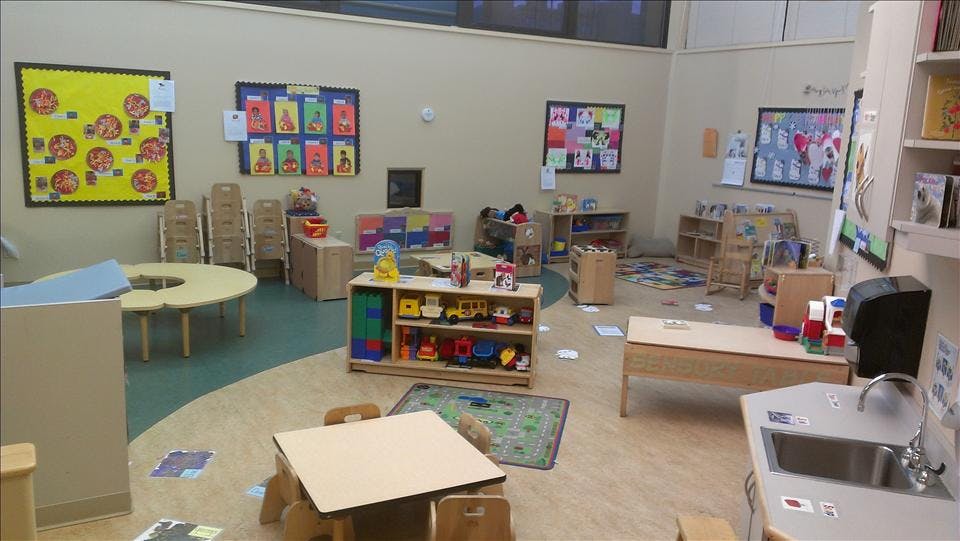 An empty early childhood classroom with activity centers and tables