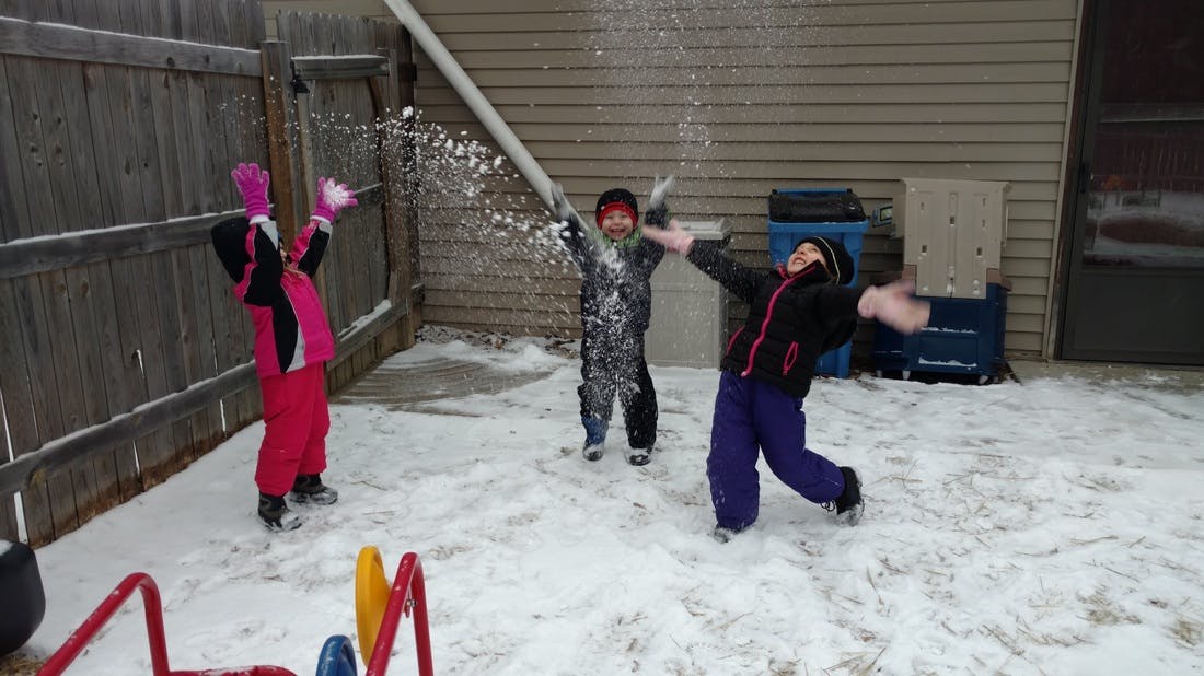Three children playing in the snow