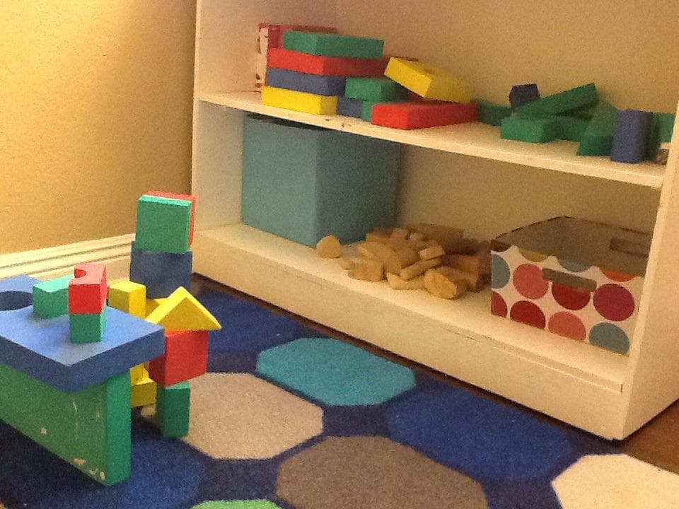 Building blocks on a rug and shelves