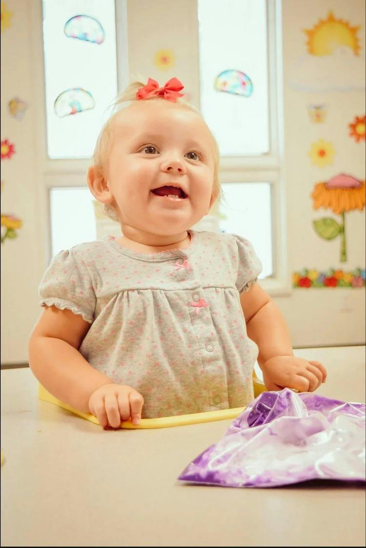 A toddler seated at a table