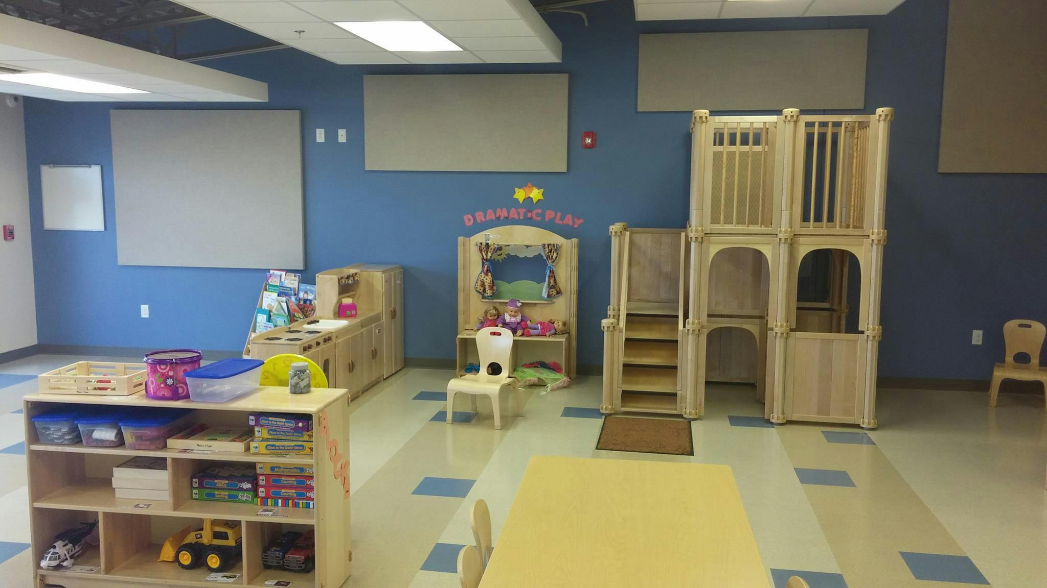 Playroom with wooden play structure and shelves