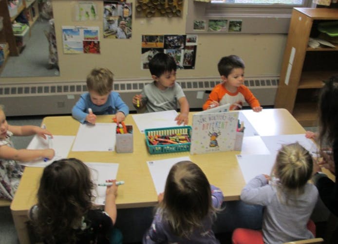 Children drawing at a table in a classroom