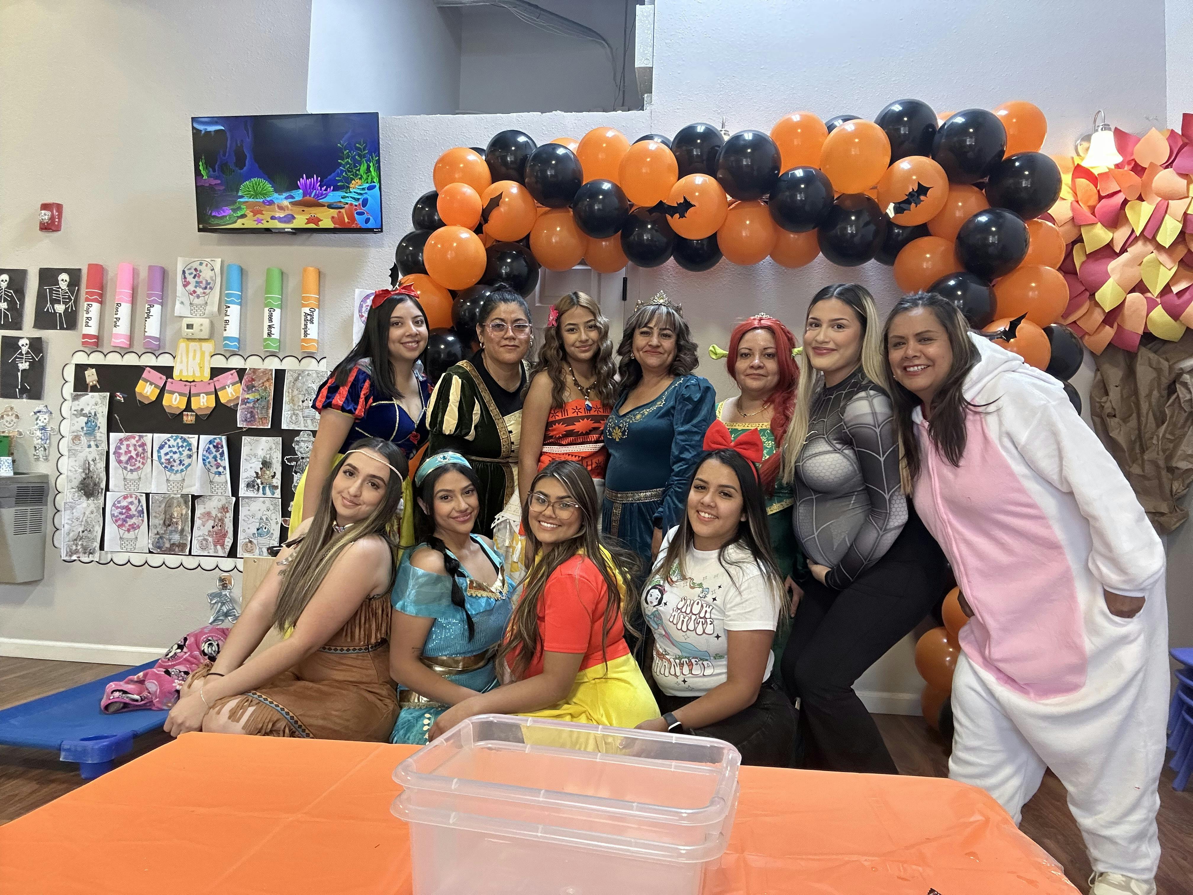 Group of people in costumes posing in front of balloons