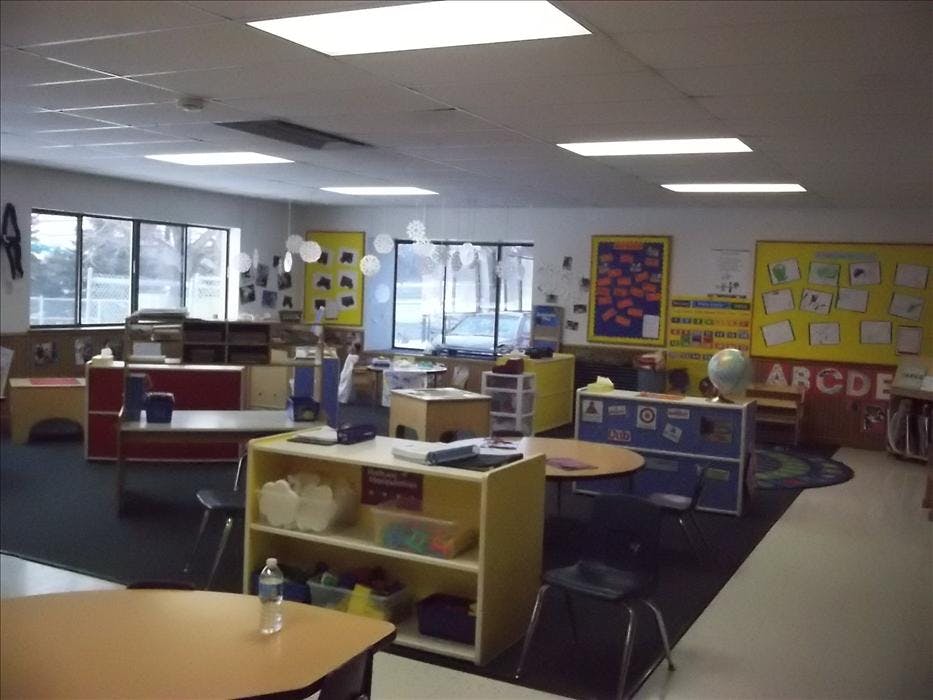 Empty classroom with tables, chairs, and learning materials