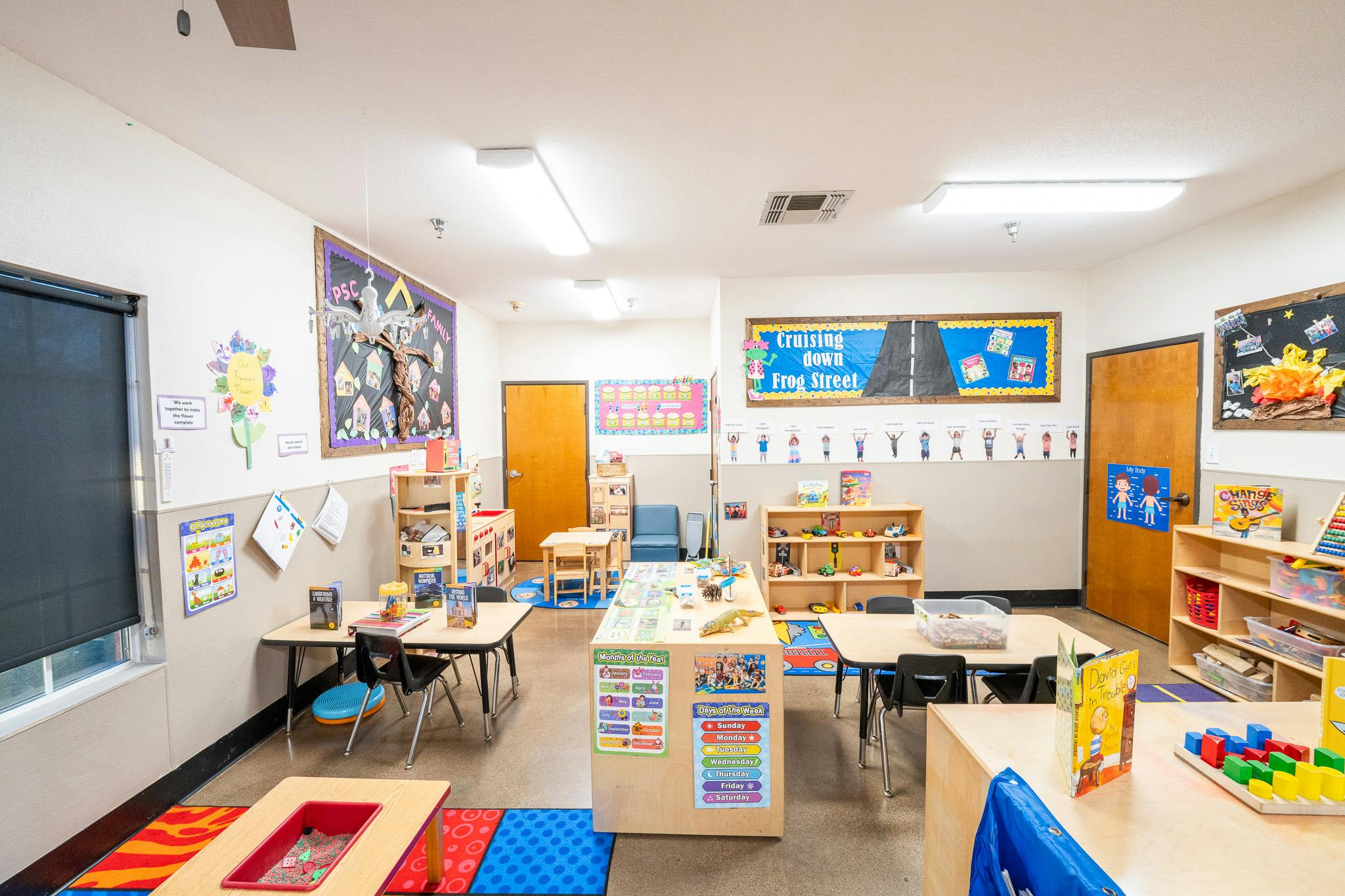 Classroom interior with small tables chairs and colorful educational wall displays