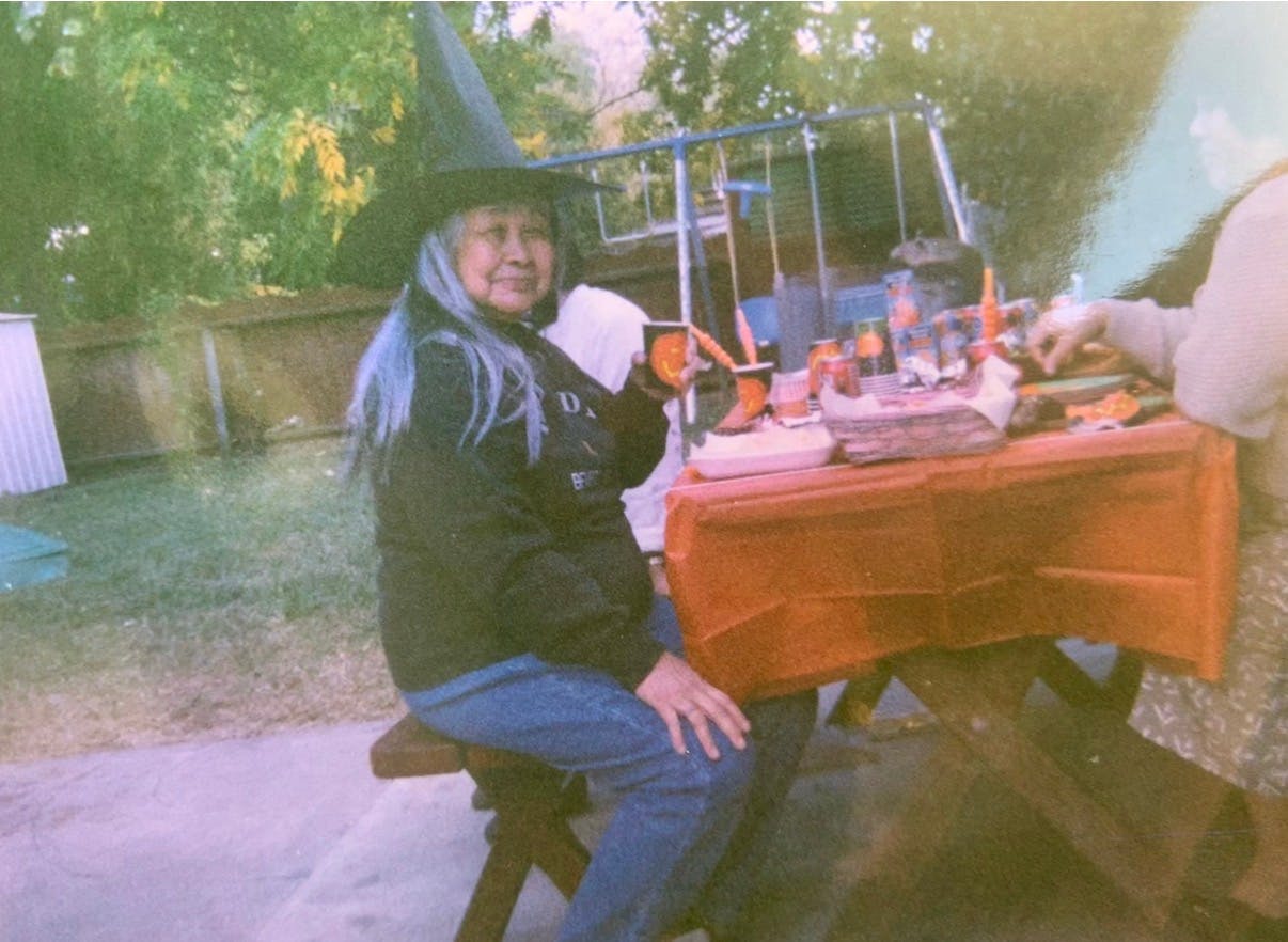Person in a witch hat sitting at a picnic table with Halloween decor