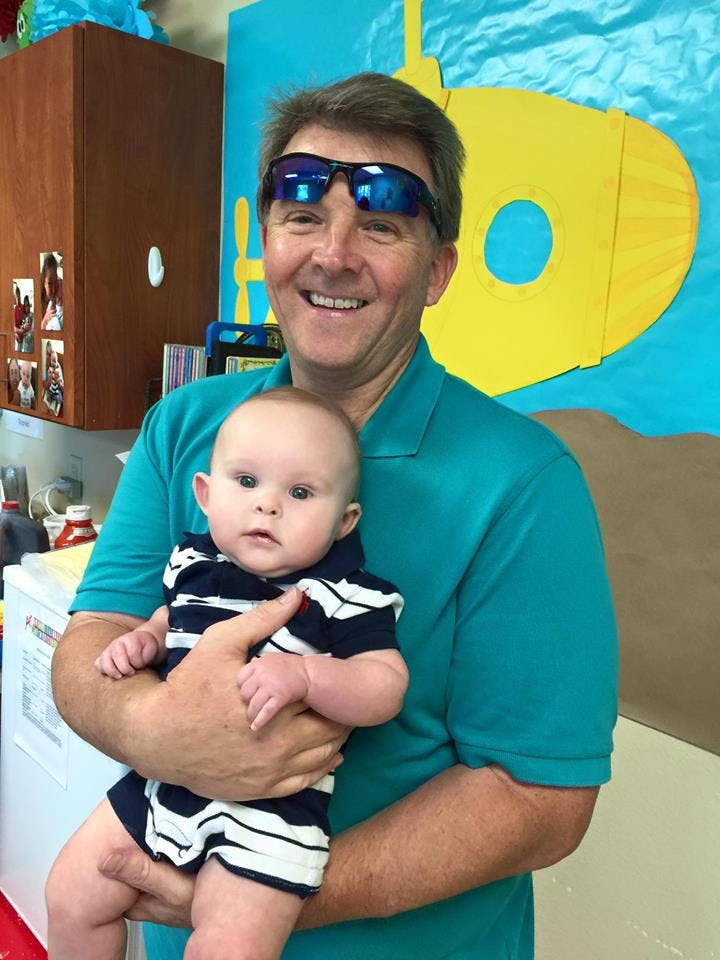 Person holding a child in a classroom