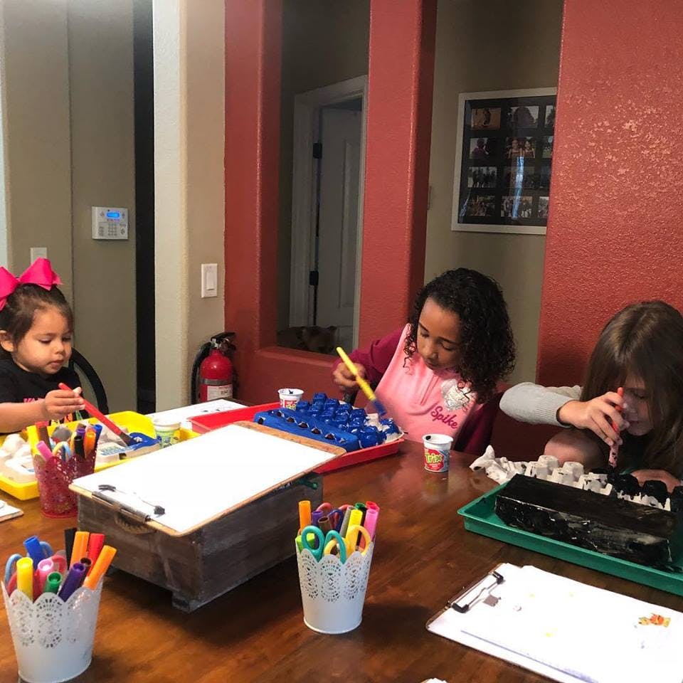 Three children at a table doing crafts
