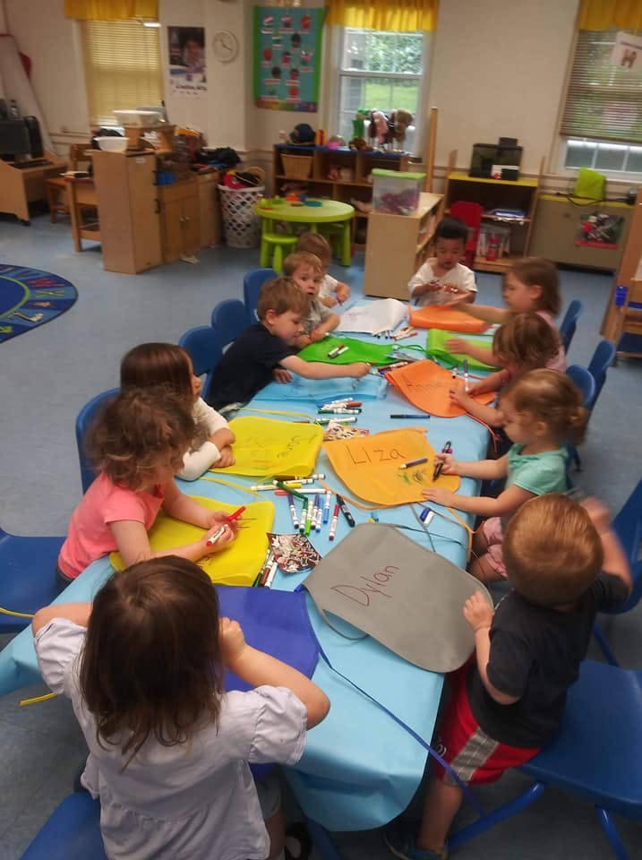 Children sitting around a table drawing and coloring