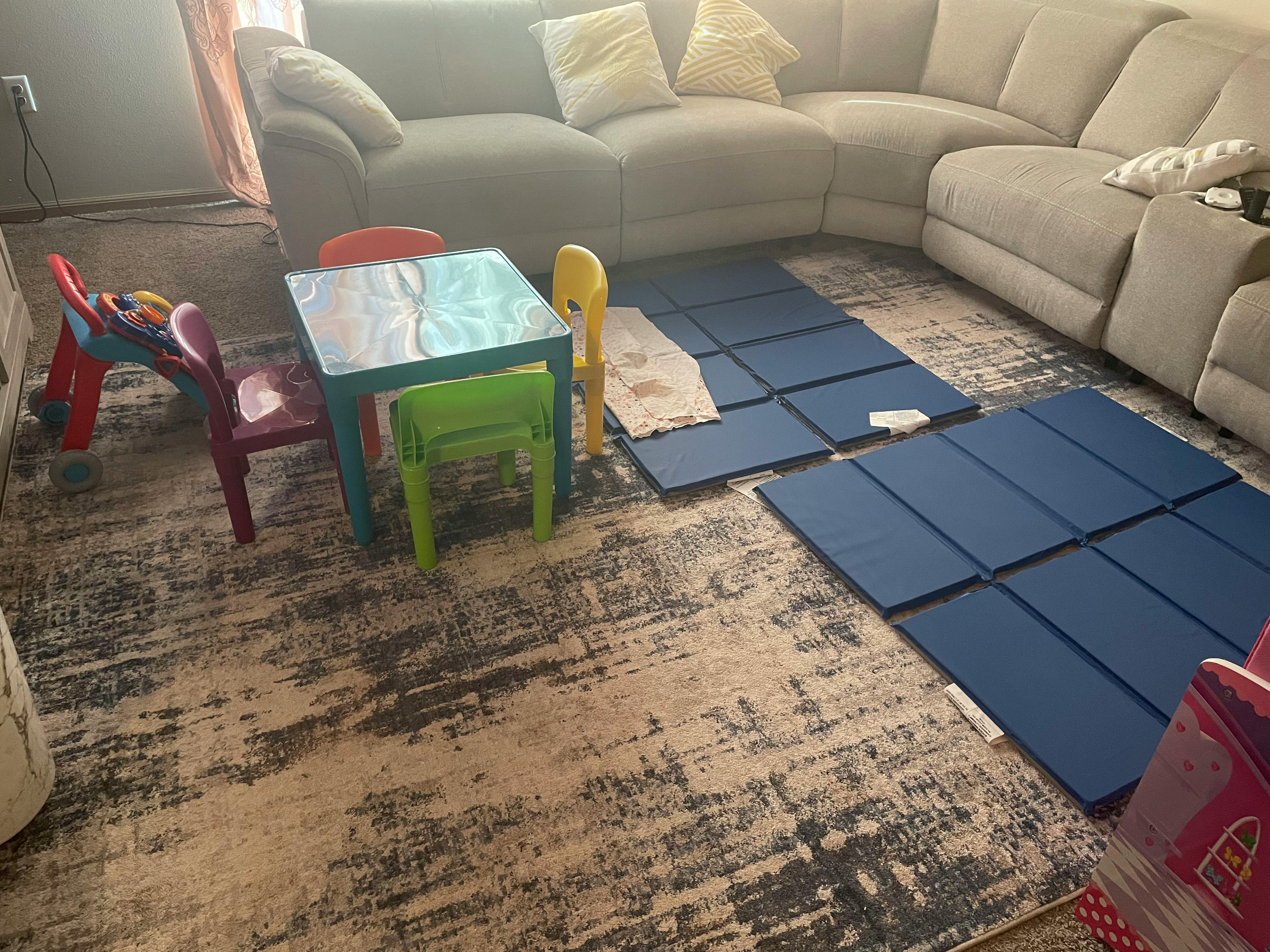 Children's table and chairs on a rug with blue mats and white mats