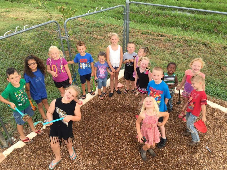 Group of children playing in a wood chip area