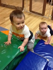 Two children crawling on soft play blocks