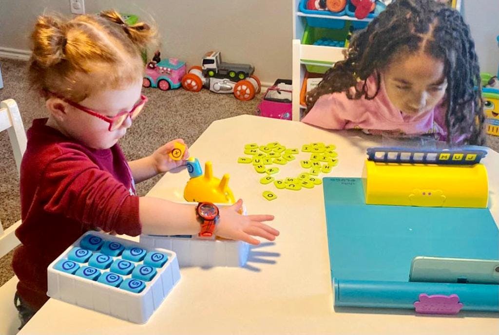 Two children playing with toys at a table