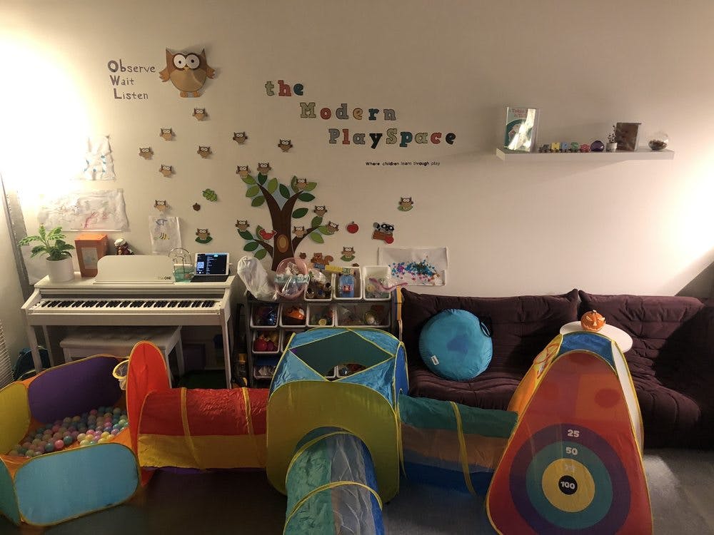 Playroom with a play tunnel, ball pit, keyboard, and wall decals