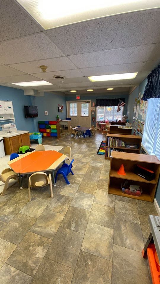 Classroom with small tables and chairs, bookshelves, and storage units