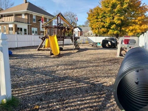 Playground with yellow slides and a large black tunnel