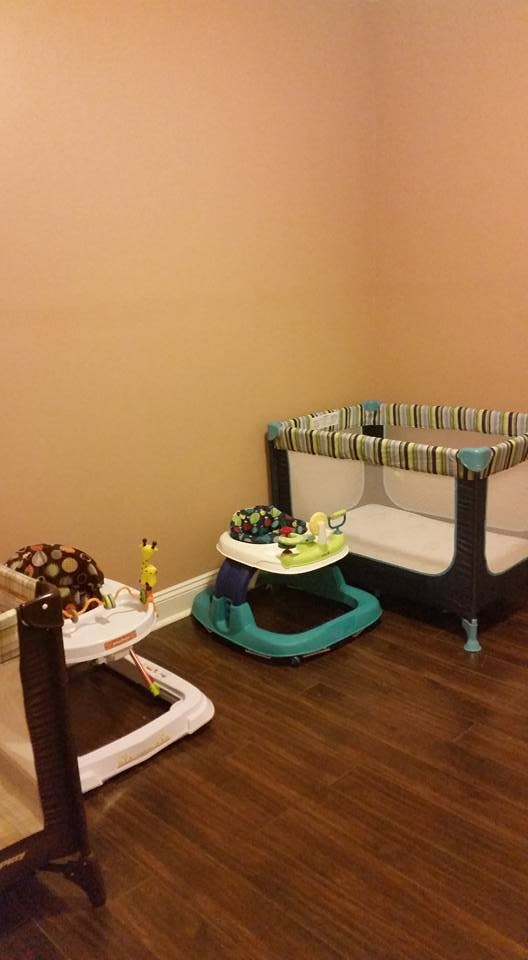 Baby playpen and two baby walkers in a room