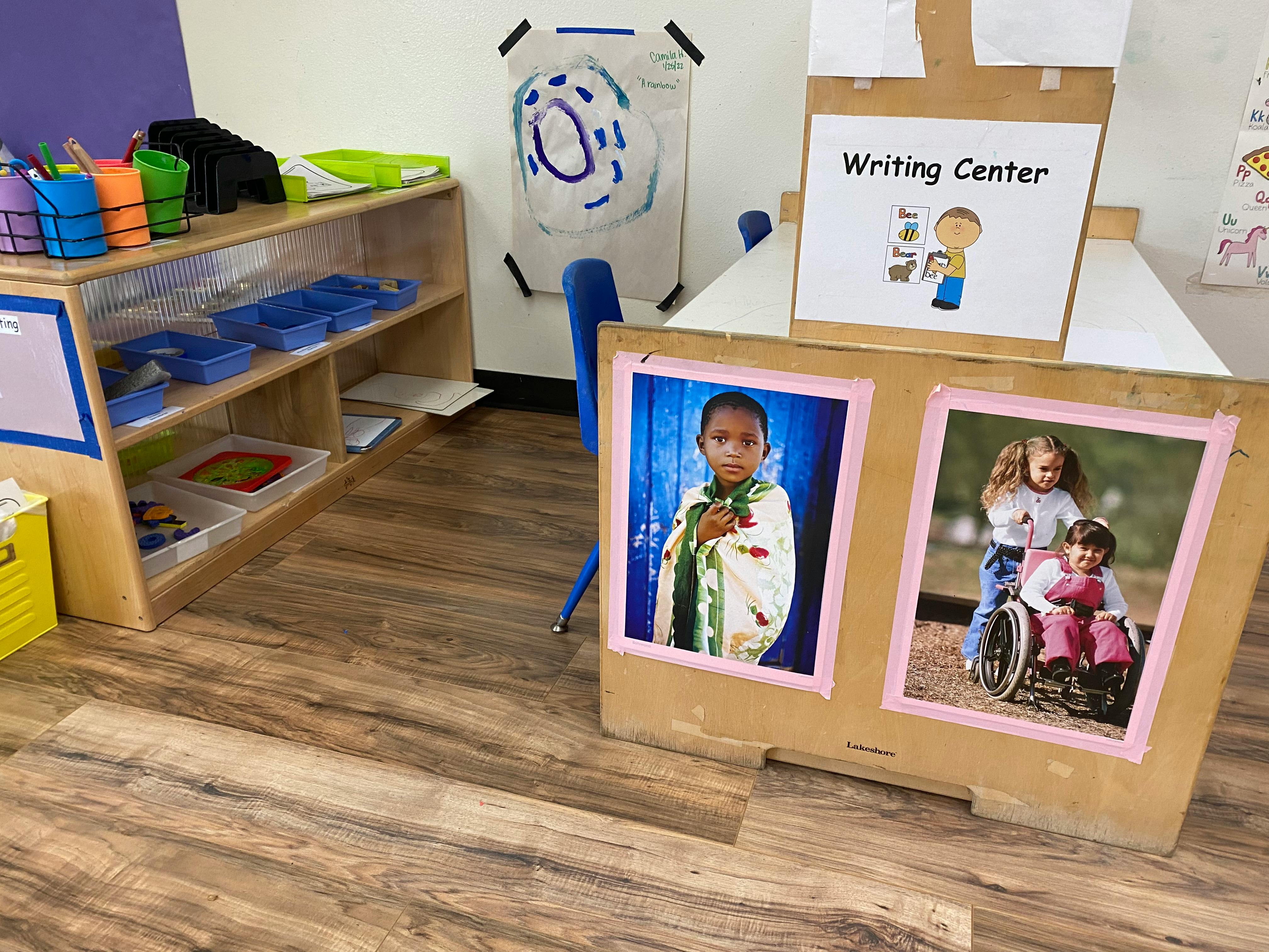 Classroom with a writing center sign and photos of children