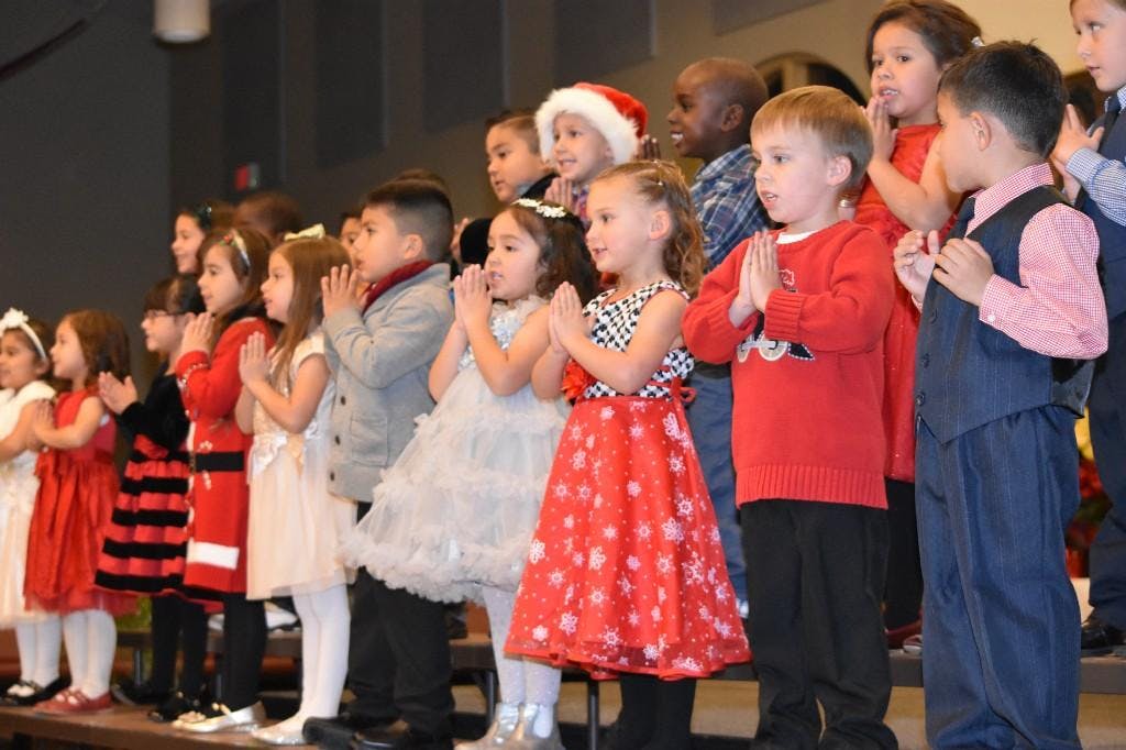 Group of children standing with hands together