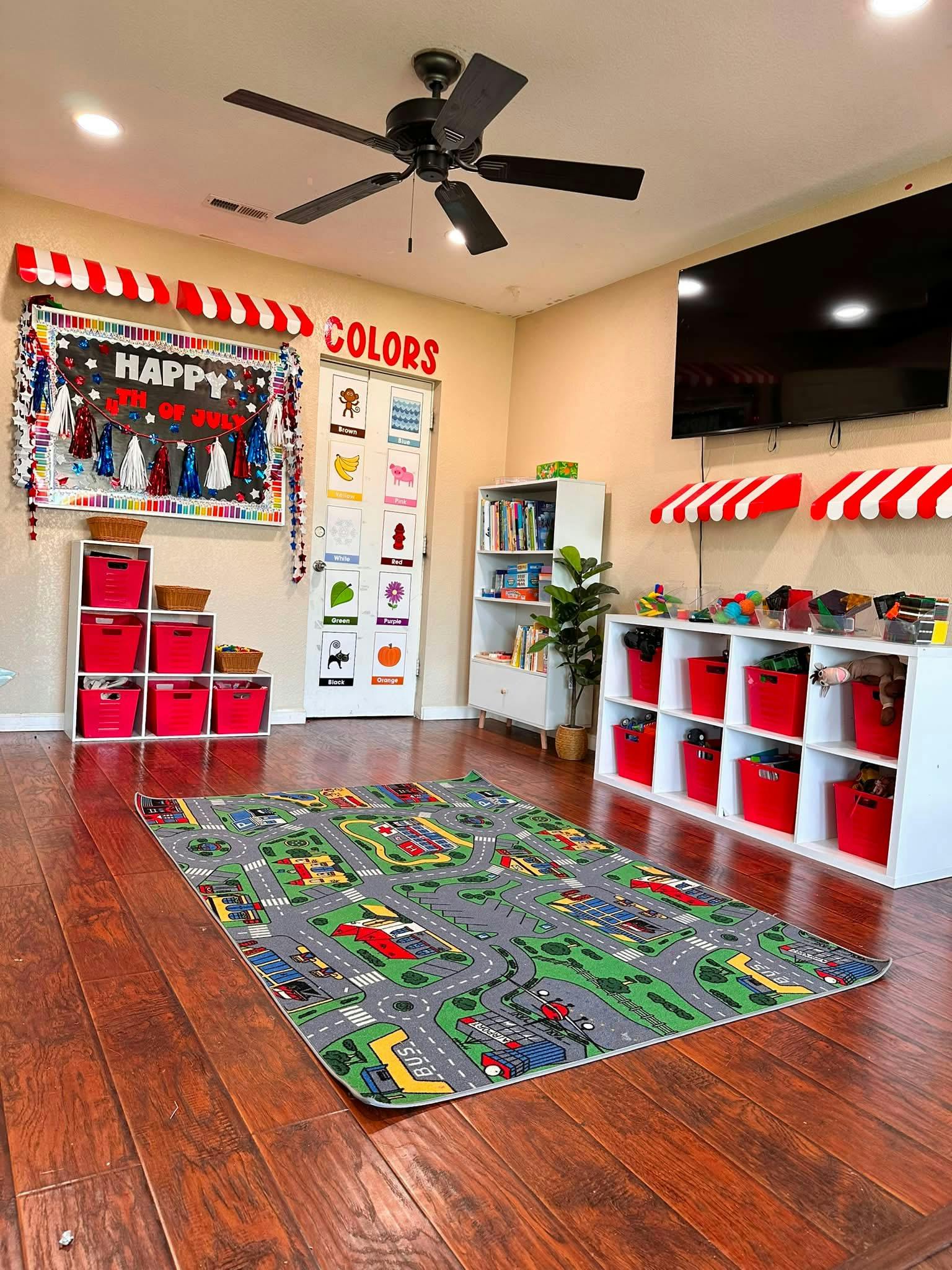 Playroom with a road-patterned rug, toy storage shelves, and learning posters