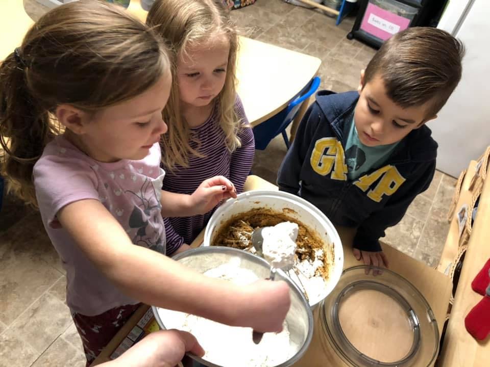 Three children mixing ingredients in bowls