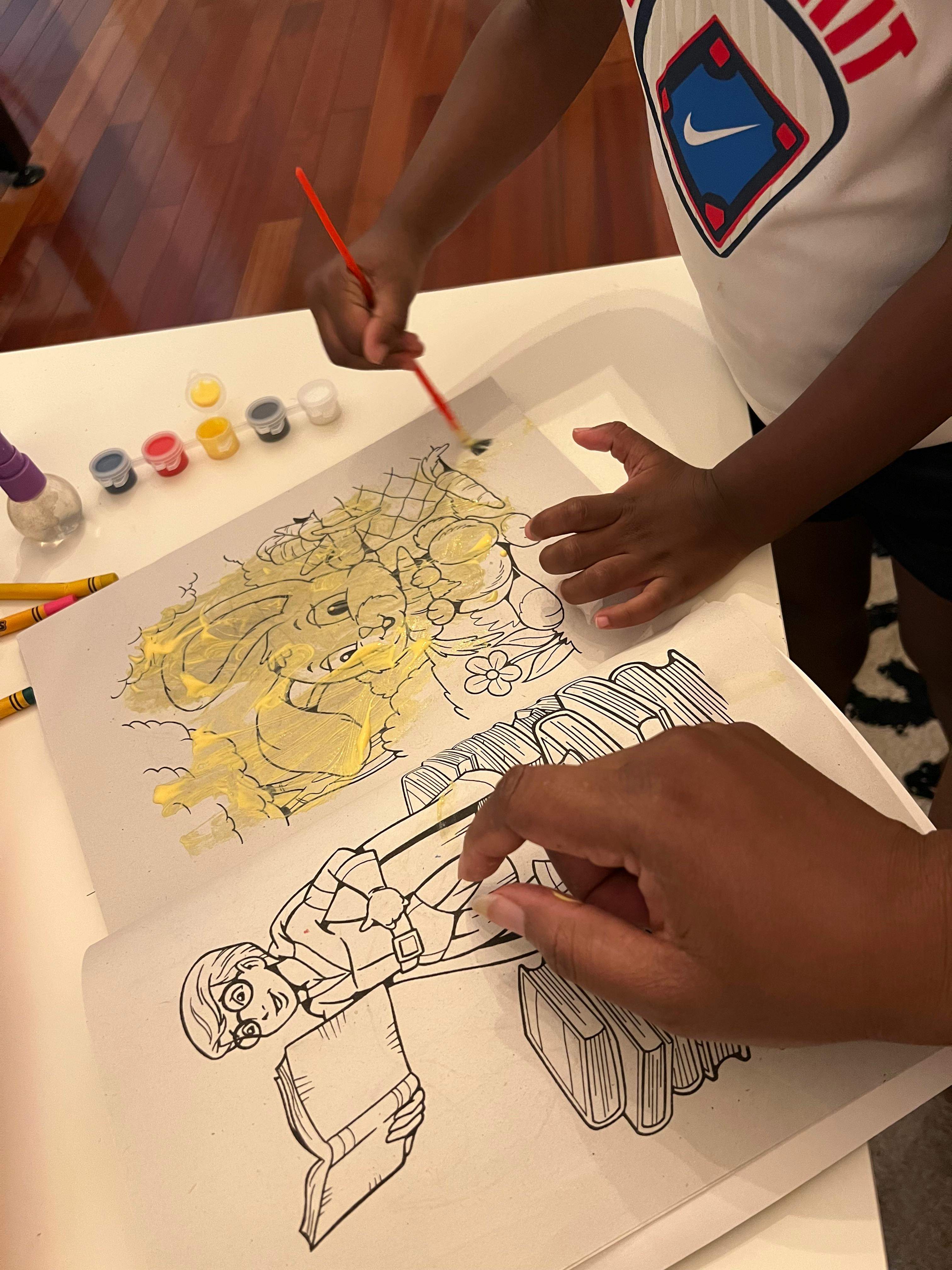 Two people painting coloring book pages