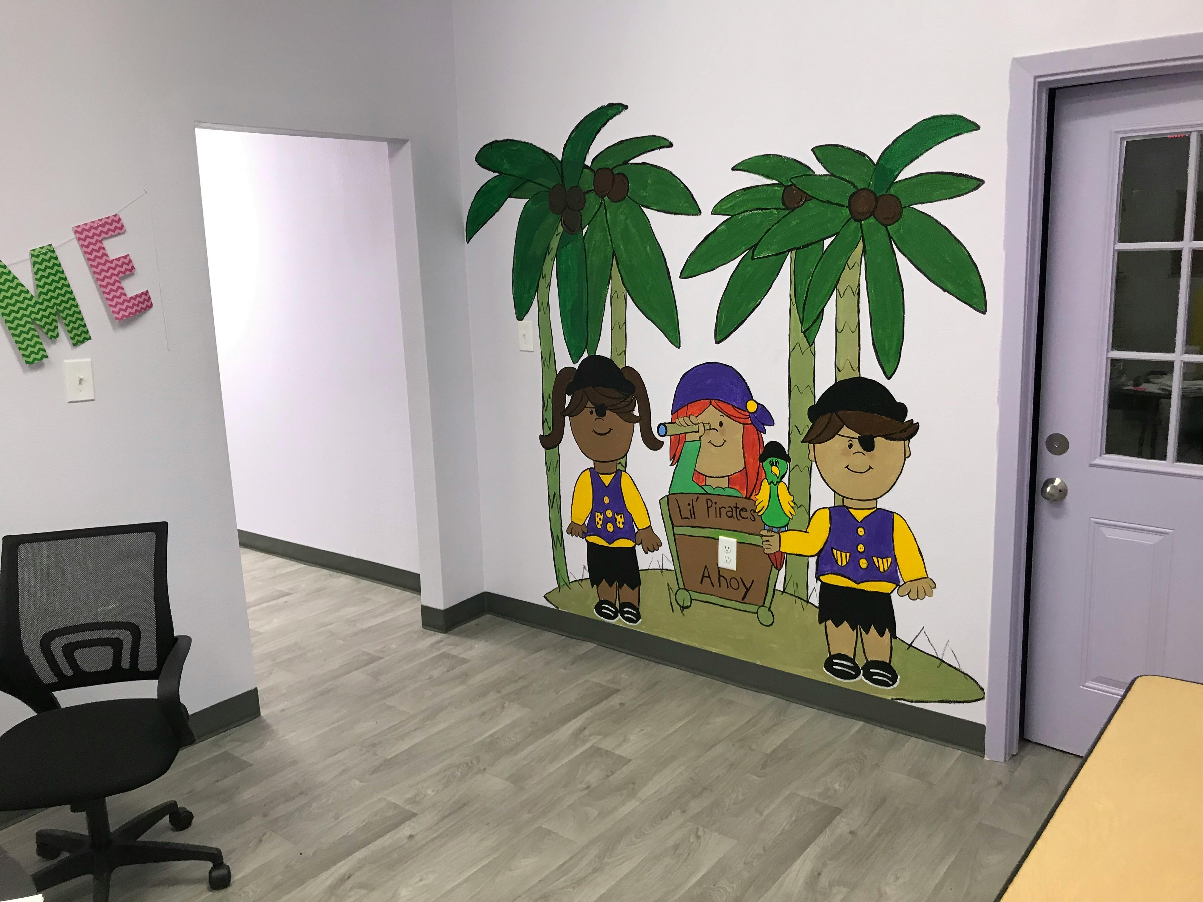 Wall mural of children dressed as pirates with palm trees