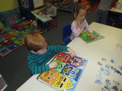 Children playing with puzzles in a classroom