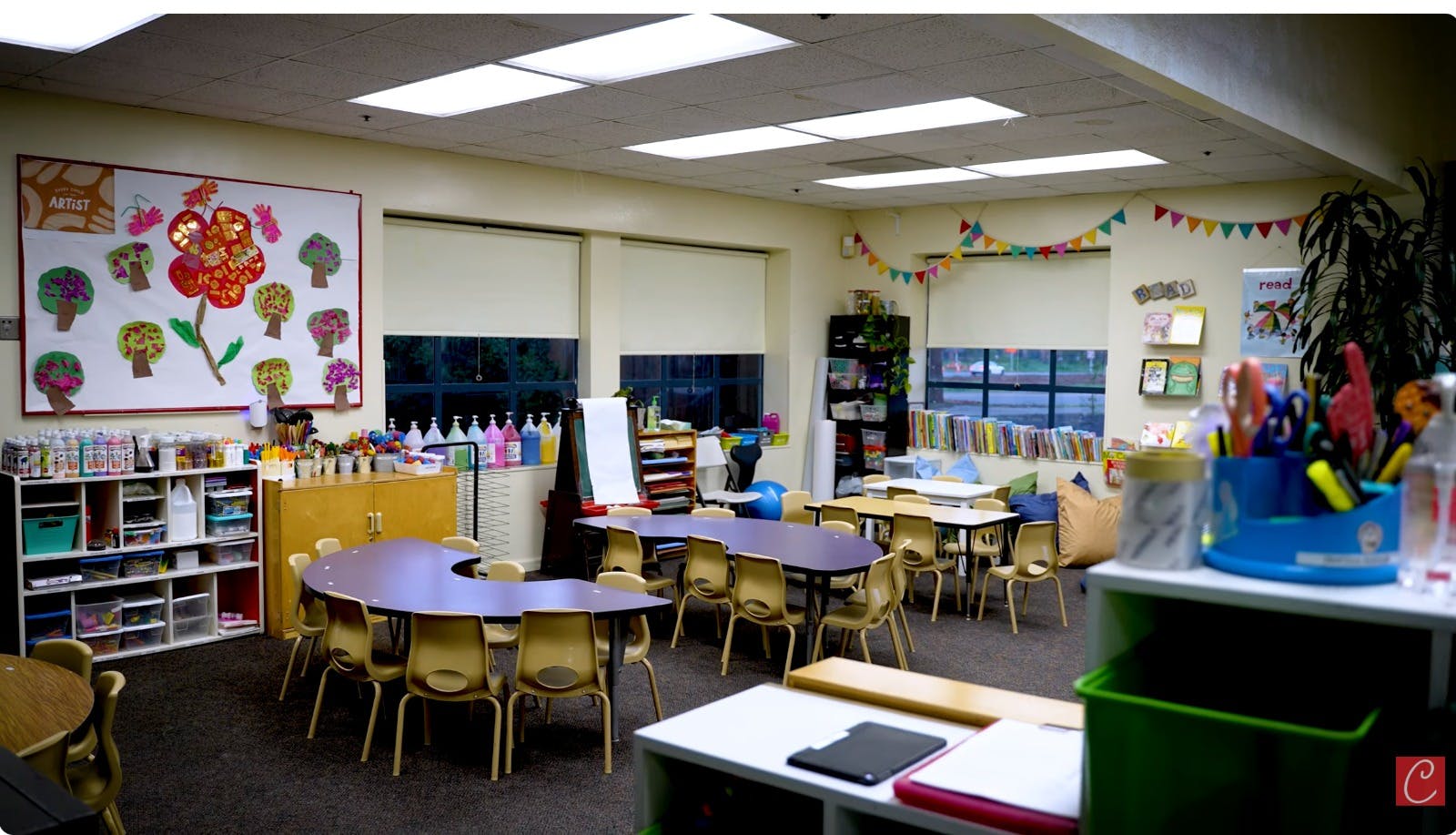 Empty classroom with tables, chairs, and colorful decorations