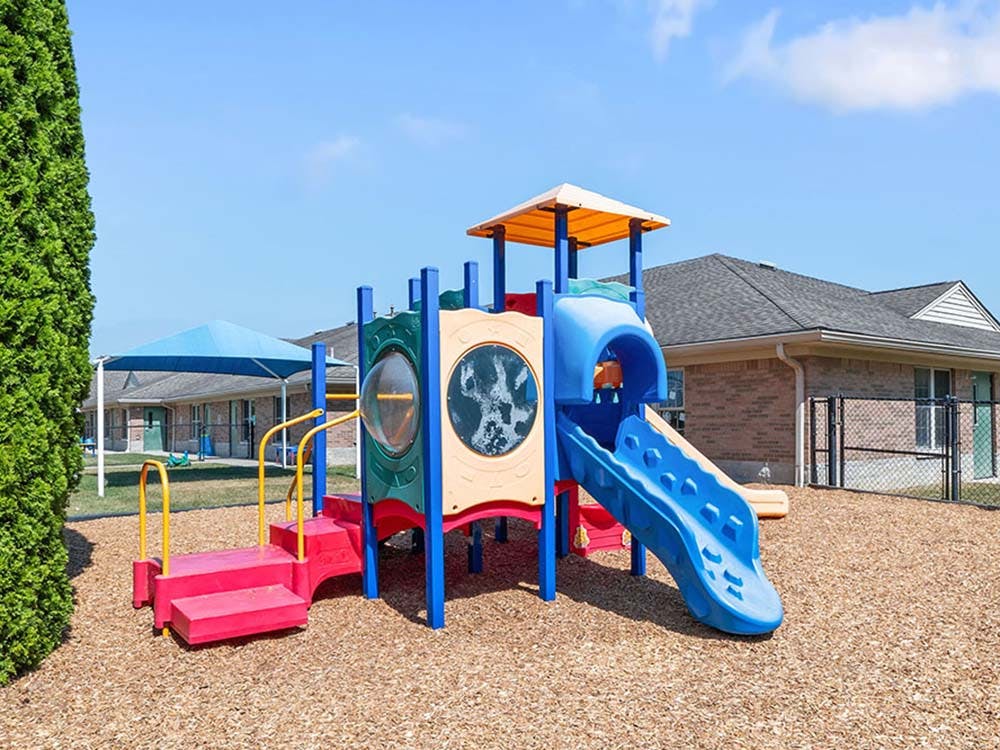 Colorful playground structure with slides on wood chip ground