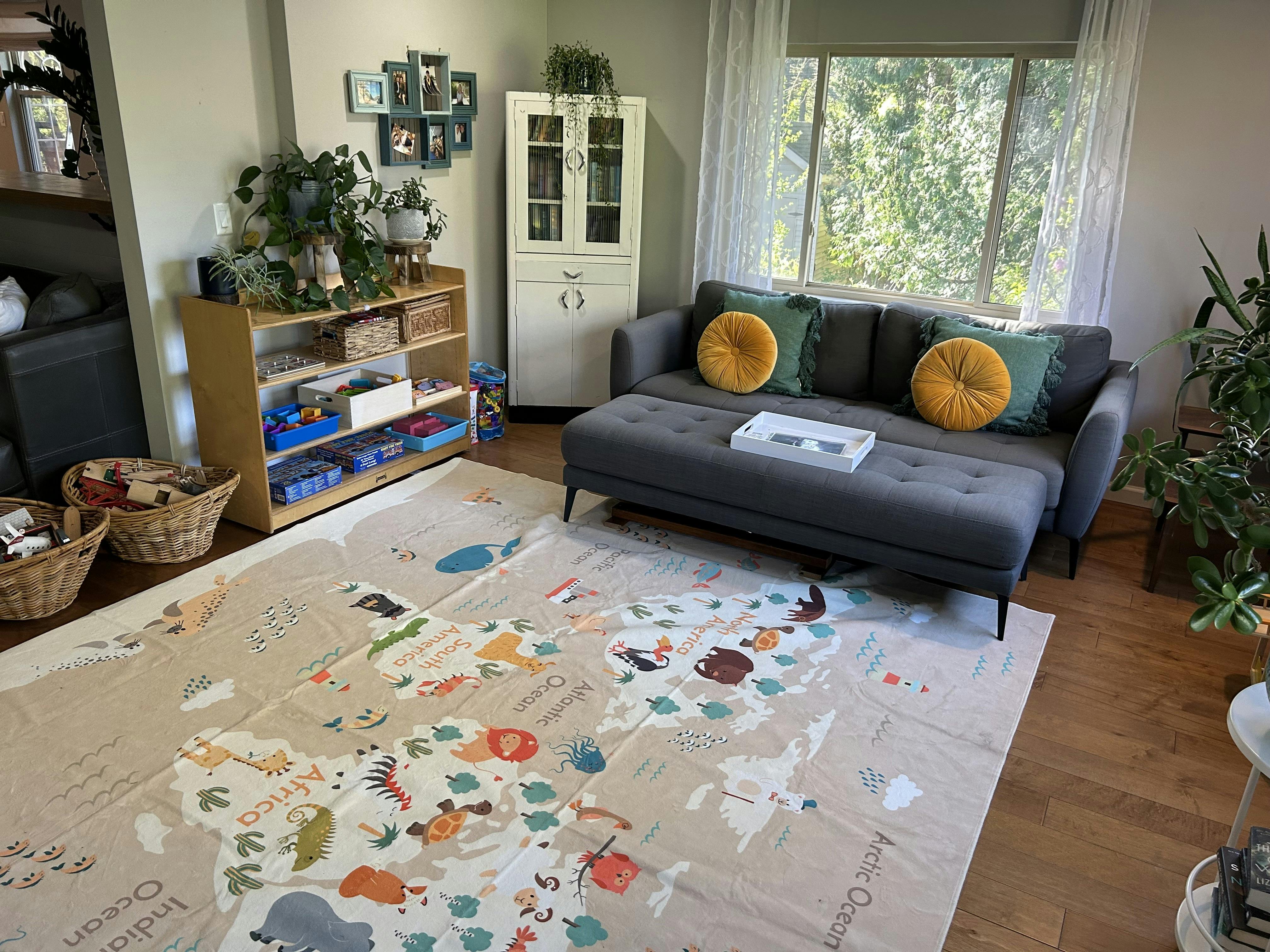 Living room with a grey sofa and a world map play mat