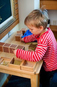 Child playing with wooden blocks at a table
