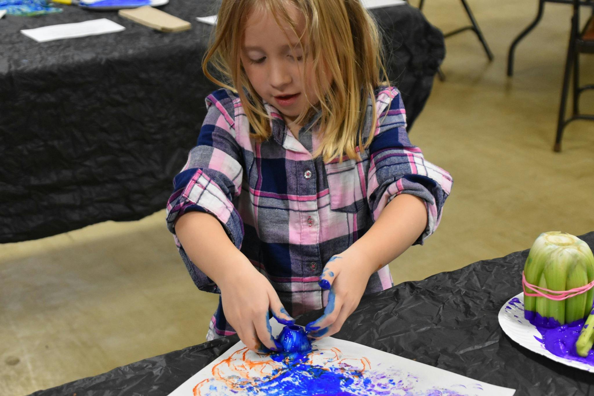 Child making art with blue paint