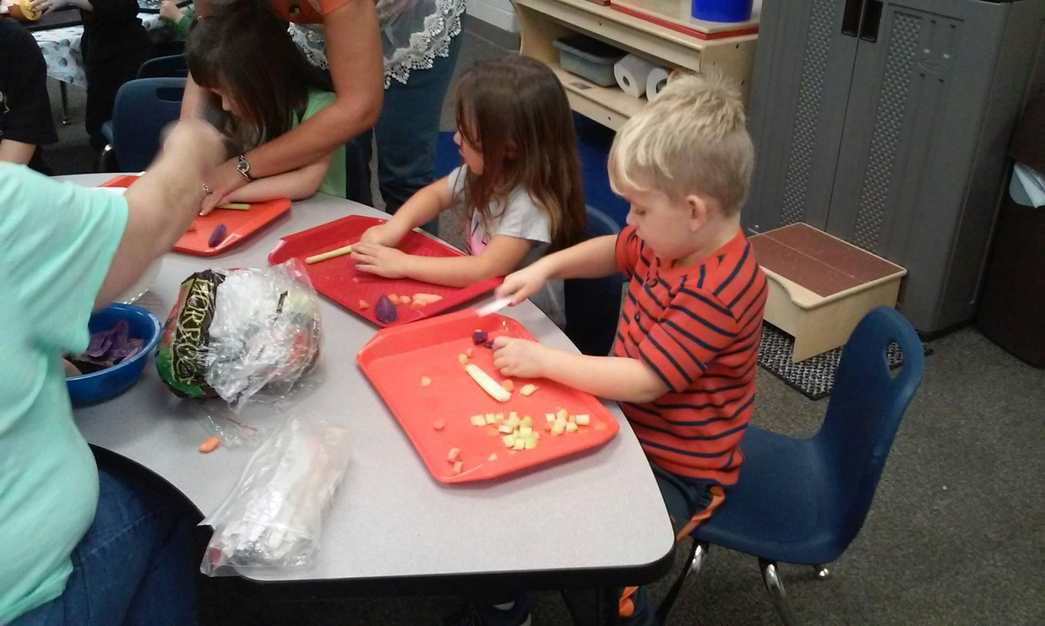 Children preparing food at a table