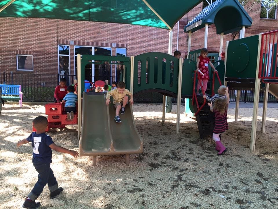 Children playing on a playground with slides and climbing structures