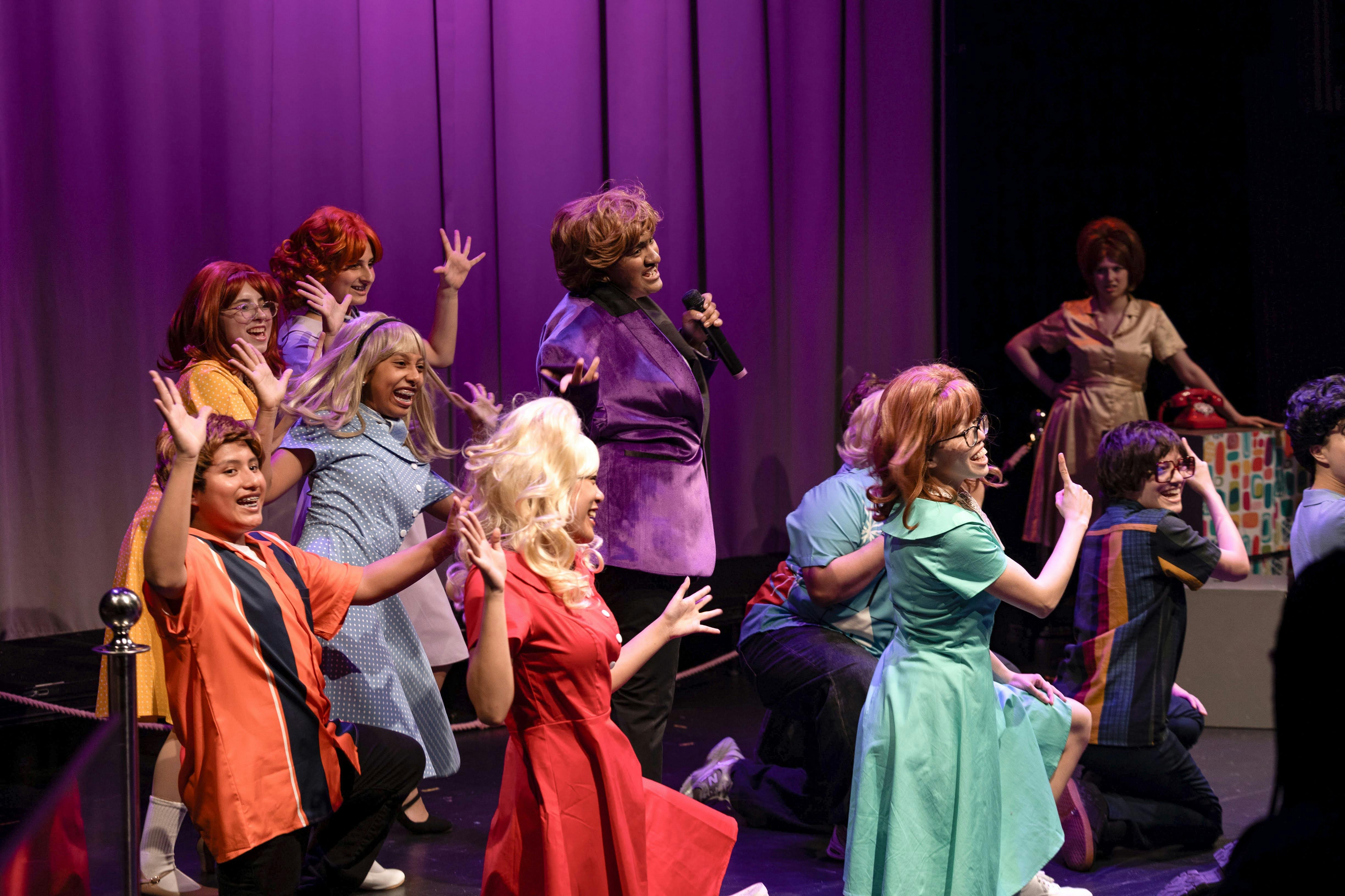 People in colorful costumes performing on a theater stage