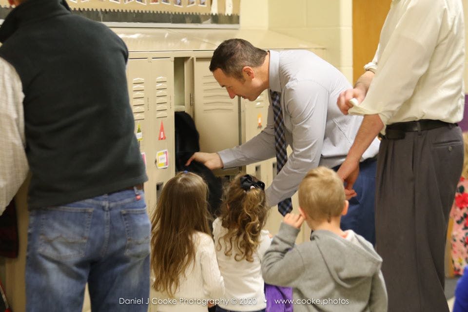 Adult person helping children with lockers