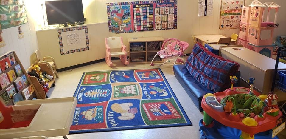 Playroom with a colorful rug, small chairs, and various toys