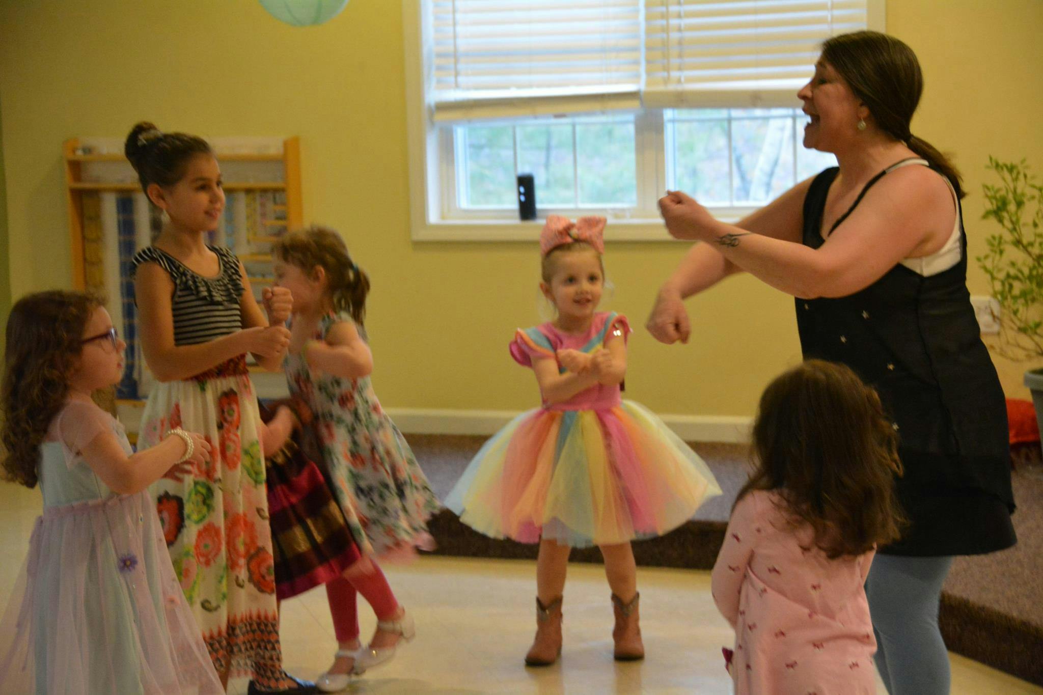Adult and children dancing in a room