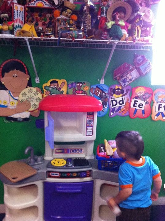 Child playing with a toy kitchen set