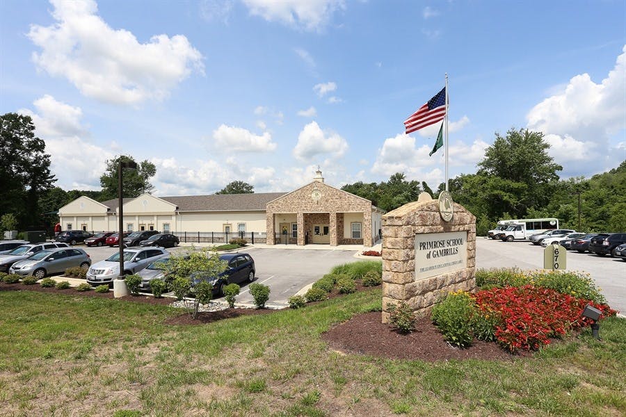 Building with a parking lot and a stone sign with an American flag