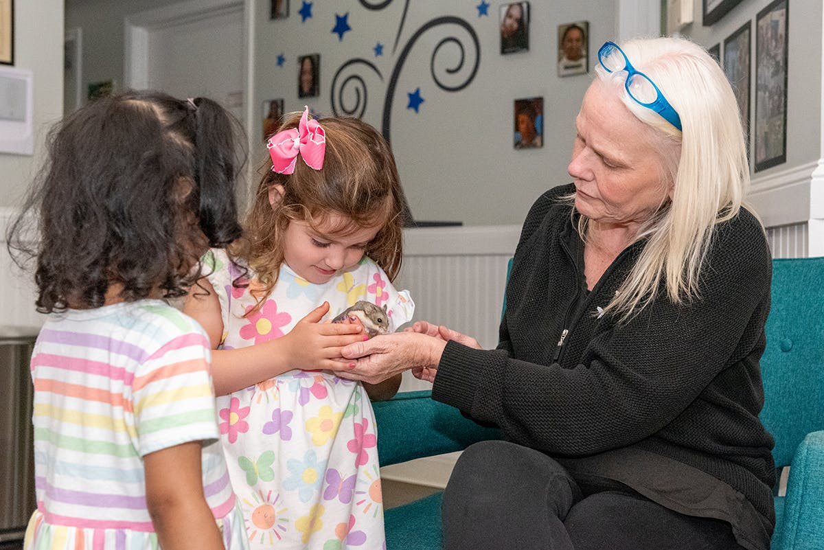 Adult and two children holding a small animal