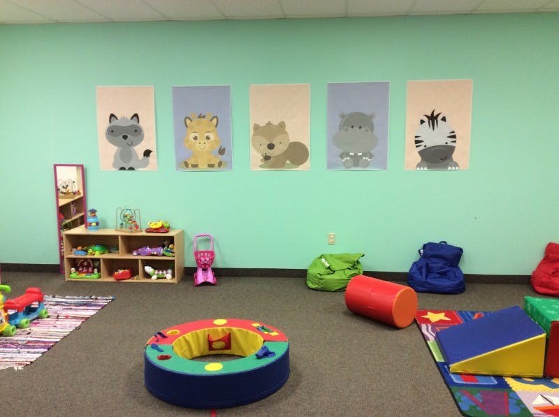 Playroom with animal pictures on wall and soft play equipment on floor